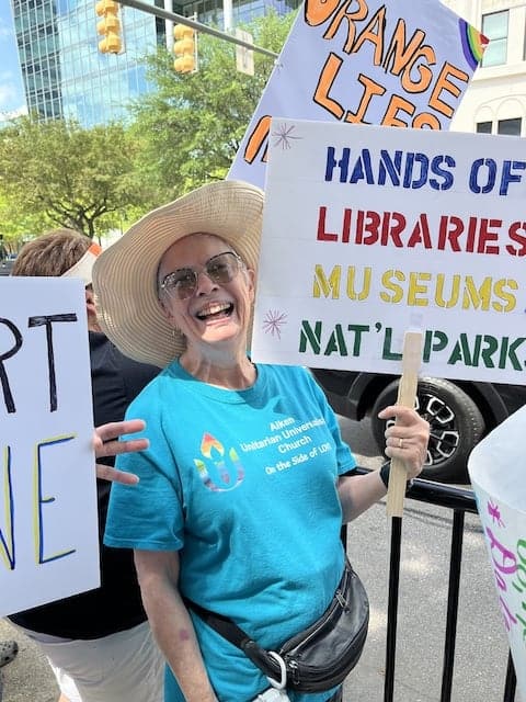 a member at the protest holding a sign